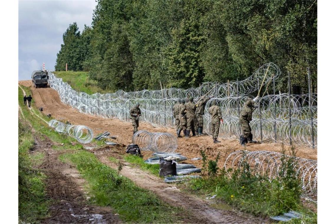Mehrere Leichen an polnisch-belarussischer Grenze entdeckt Polnische Soldaten errichten Anfang September einen Stacheldrahtzaun entlang der polnisch-belarussischen Grenze. In dem Grenzgebiet sind die Leichen von drei Menschen gefunden worden. Foto: Attila Husejnow/SOPA Images via ZUMA Press Wire/dpa