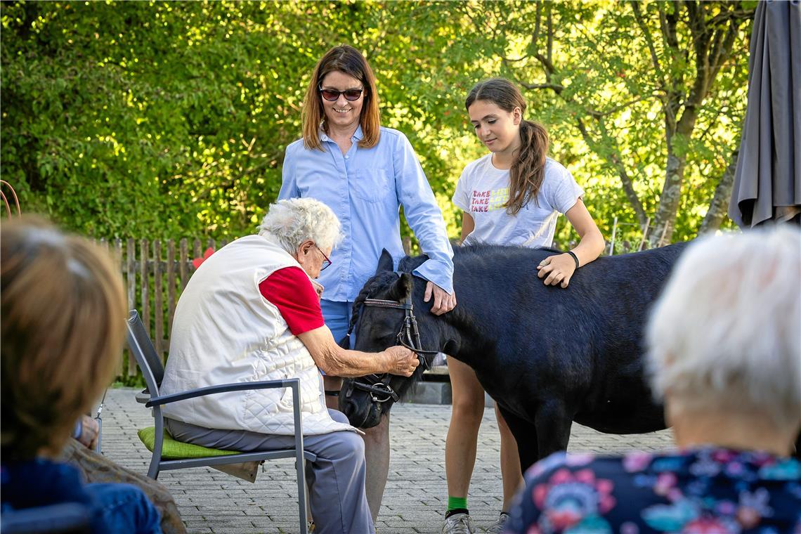 Pony Princess ist beliebt in der Weissacher Diakoniestation. Bei Besucherinnen der Tagespflege wie der 93-jährigen Katharina Harr (links) kommen Erinnerungen an eigene Tiere hoch. Auch deshalb bieten Antje Kluge (Mitte) und Jule Helbig solche Besuche an. Foto: Alexander Becher