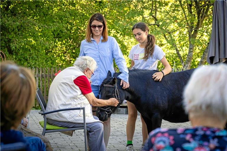 Pony Princess ist beliebt in der Weissacher Diakoniestation. Bei Besucherinnen der Tagespflege wie der 93-jährigen Katharina Harr (links) kommen Erinnerungen an eigene Tiere hoch. Auch deshalb bieten Antje Kluge (Mitte) und Jule Helbig solche Besuche an. Foto: Alexander Becher