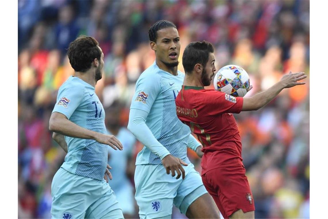 Portugal gewinnt die erste Ausgabe der Nations League Portugals Bernardo Silva (r) nimmt den Ball vor Virgil Van Dijk mit der Brust an. Foto: Martin Meissner/AP