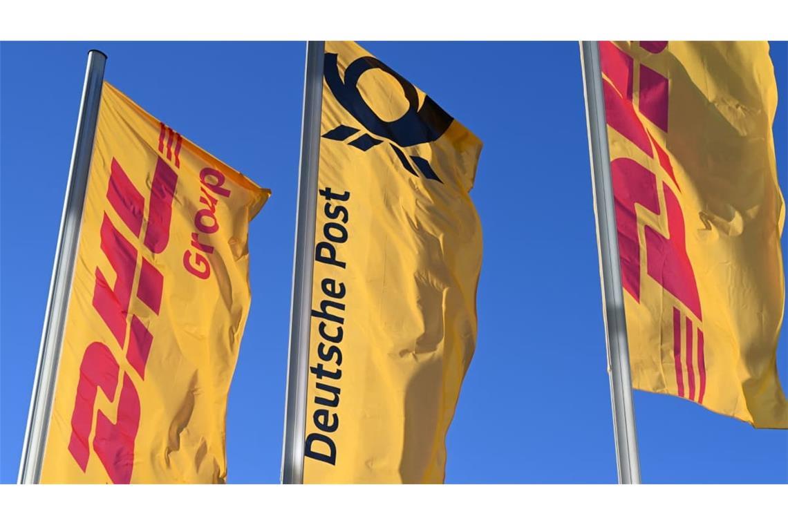 Post-Fahne mit Posthorn: ARCHIV - 13.01.2025, Nordrhein-Westfalen, Bonn: Fahnen des Logistikkonzerns DHL und seiner Brieftochter Deutsche Post (M) wehen vor der Konzernzentrale an Masten. Der Konzern hat sich von Deutsche Post AG zu DHL AG umbenannt. (zu dpa: «Bonner Logistikkonzern heißt jetzt DHL statt Deutsche Post») Foto: Wolf von Dewitz/dpa +++ dpa-Bildfunk +++