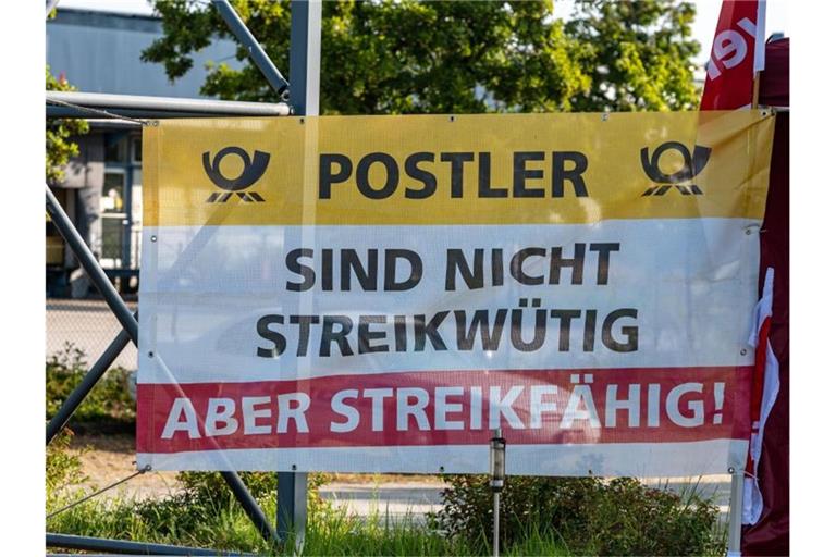 „Postler - Sind nicht streikwütig aber streikfähig!“" steht auf einem Plakat vor dem Briefzentrum der Post in Straubing. Foto: Armin Weigel/dpa