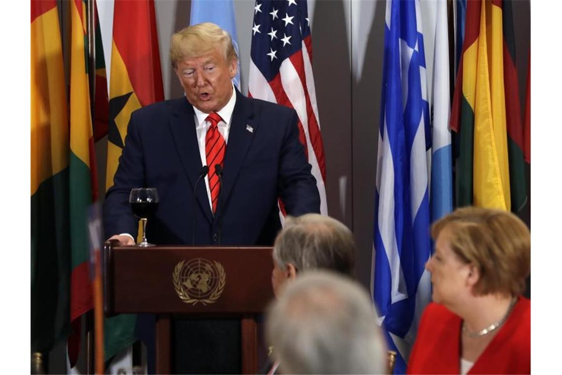 Präsident Donald Trump (l) hält eine Ansprache bei einem Mittagessen das von Antonio Guterres (M), UN-Generalsekretär, ausgerichtet wird. Bei dem im Rahmen der UN-Generalversammlung stattfindenden Essen ist unter anderem auch Bundeskanzlerin Angela Merkel (CDU, r) anwesend. Foto: Evan Vucci/AP