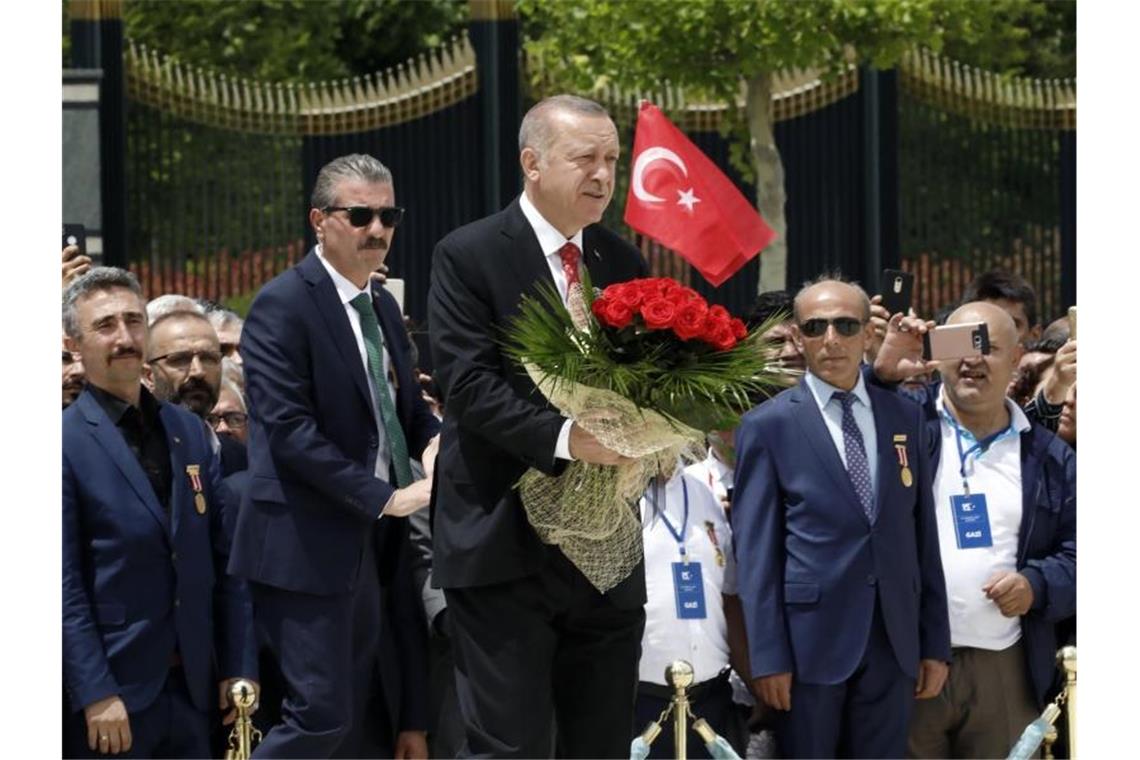 Präsident Recep Tayyip Erdogan (M) legt einen Blumenstrauß vor dem Märtyrer-Denkmal in Ankara nieder. Foto: Burhan Ozbilici/AP