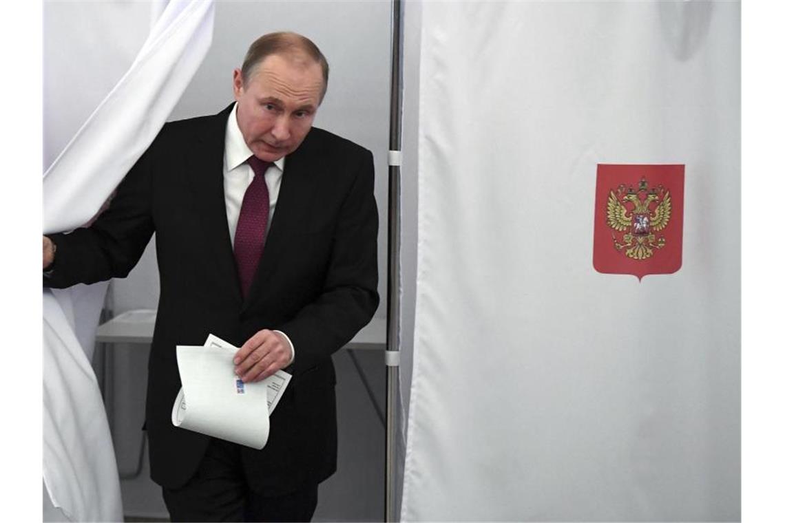 Kreml und Opposition zufrieden mit Ergebnis Präsident Wladimir Putin kommt in Moskau aus der Wahlkabine. Foto: Yuri Kadobnov/POOL AFP/AP