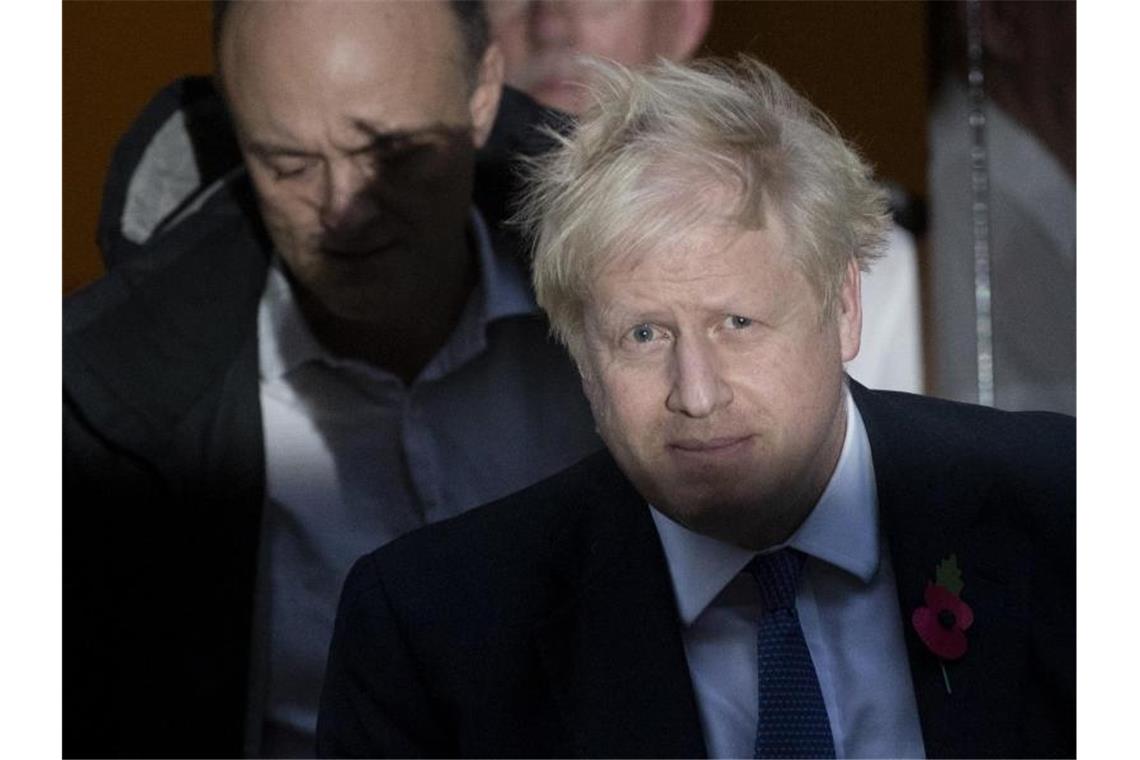 Premier Boris Johnson (l) und sein wichtigster Berater Dominic Cummings. Ein weiterer Mitarbeiter musste nach rassistischen Äußerungen gehen. Foto: Matt Dunham/AP/dpa