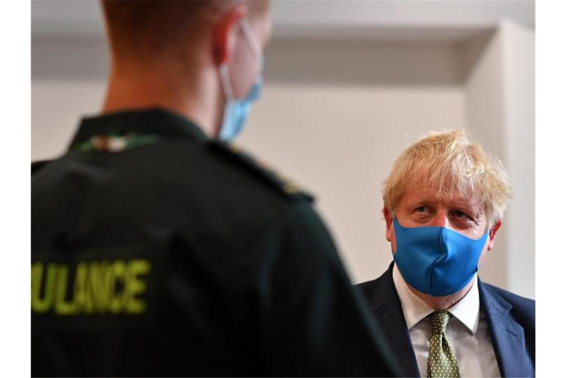 Großbritannien in der Klemme: Corona und Brexit-Folgen Premier Boris Johnson spricht während eines Besuchs im Hauptquartier des London Ambulance Service NHS Trust mit einem Sanitäter. Foto: Ben Stansall/PA Wire/dpa