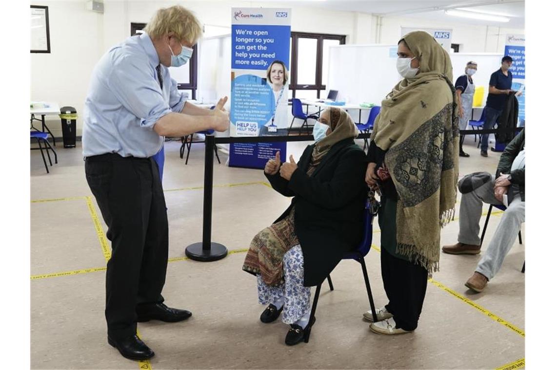 Premierminister Boris Johnson (l.) zeigt bei einem Besuch in einem Impfzentrum den Patienten den Daumen nach oben. Foto: Jon Super/AP Pool/AP/dpa