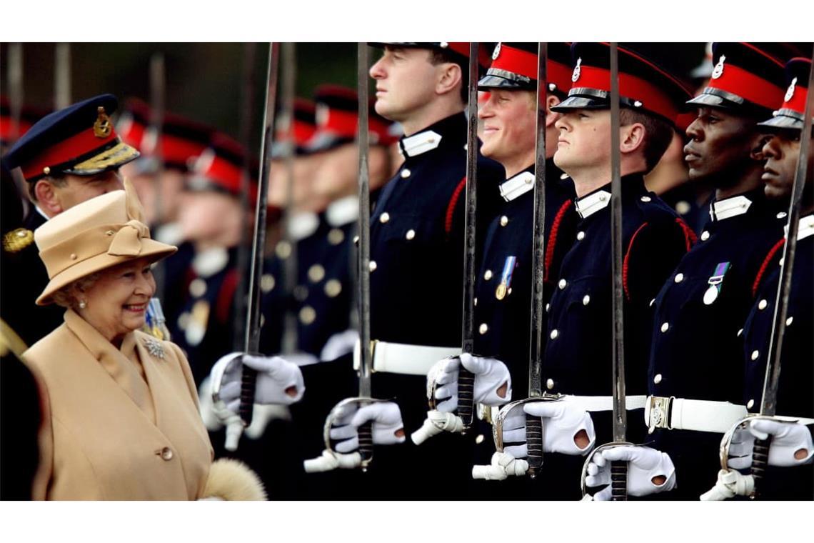 Prinz Harry lächelt breit, während seine Großmutter Königin Elizabeth II. ihn und andere Offiziere bei der „Sovereign’s Parade“ an der Royal Military Academy Sandhurst in Surrey anlässlich des Abschlusses ihrer Ausbildung inspiziert.