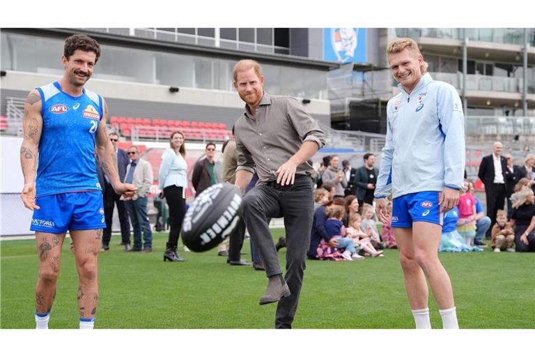 Prinz Harry (M), Herzog von Sussex, kickt einen Football.