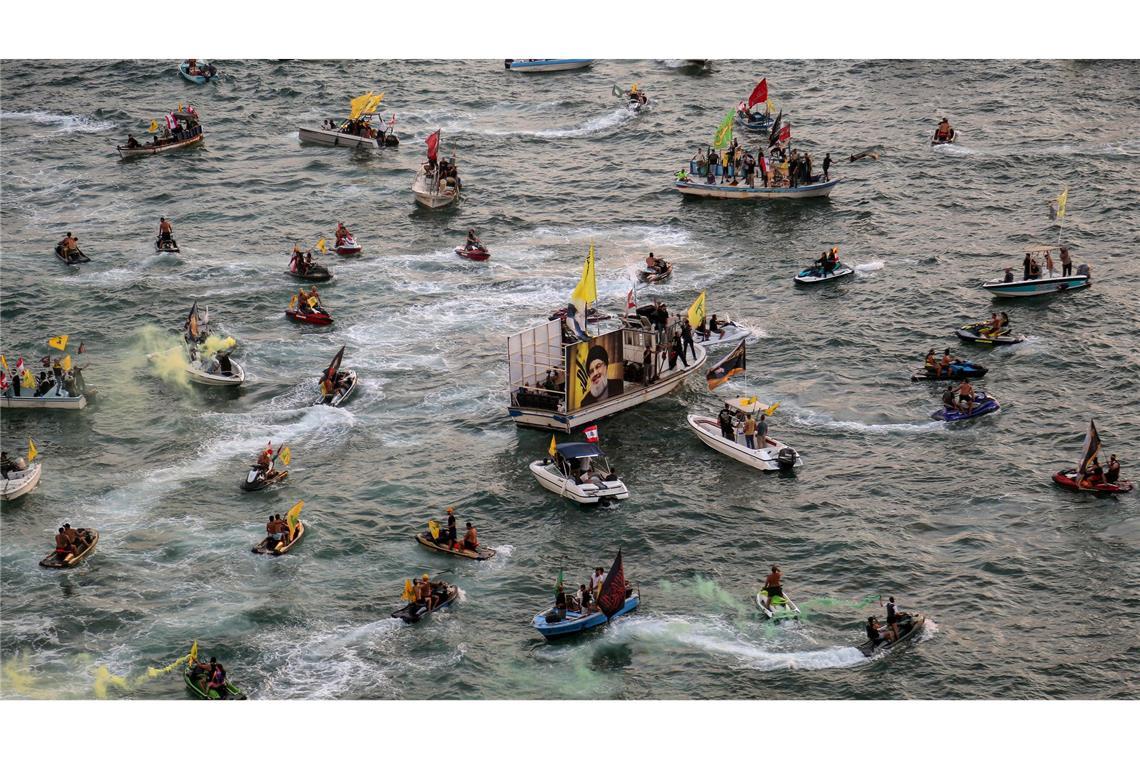 Bilder des Tages Pro-iranische Hisbollah-Anhänger auf kleinen Booten paradieren in der Nähe des libanesischen Taubenfelsens während einer Veranstaltung zum ersten Jahrestag der Tötung von Parteichef Hassan Nasrallah.