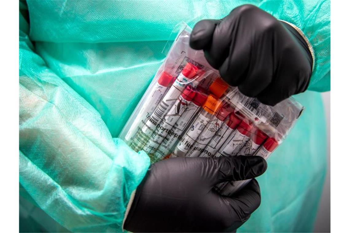 12.802 Corona-Neuinfektionen und 891 neue Todesfälle Proben PCR-Tests werden von einem Mitarbeiter in einem Corona-Testzentrum verpackt. Foto: Sina Schuldt/dpa