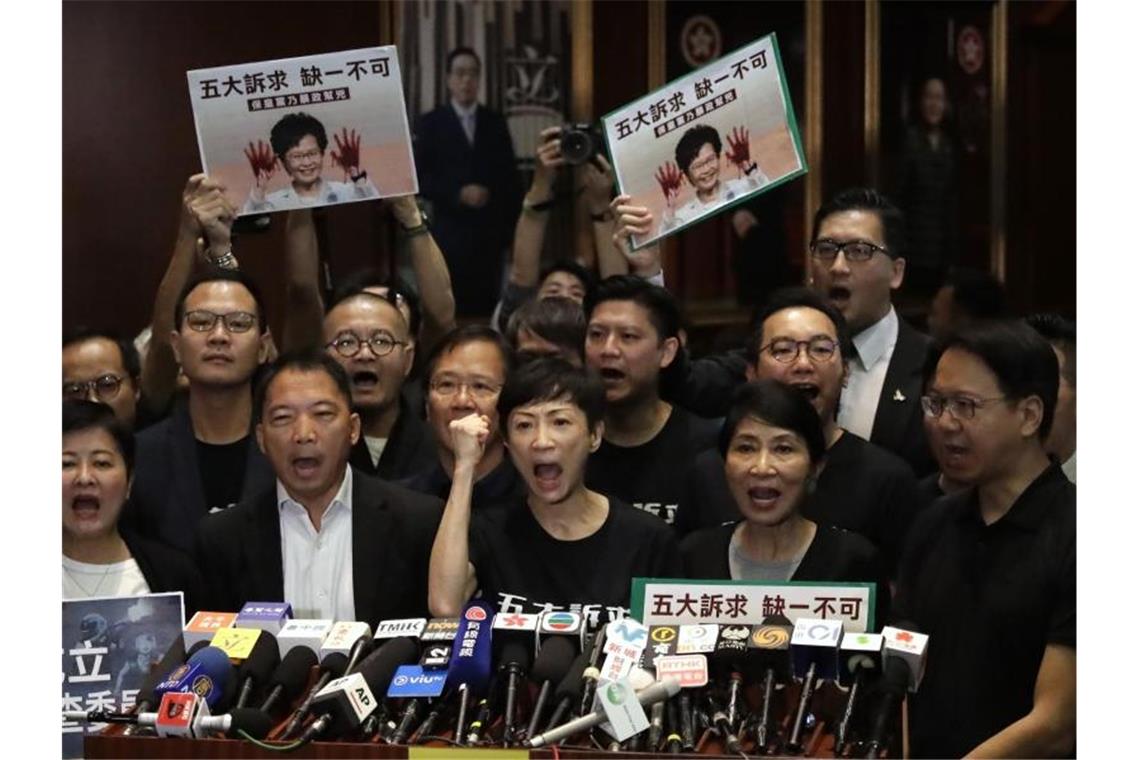 Prodemokratische Abgeordnete rufen bei einer Pressekonferenz, nachdem Regierungschefin Lam den Legislativrat verlassen hat. Foto: Mark Schiefelbein/AP/dpa