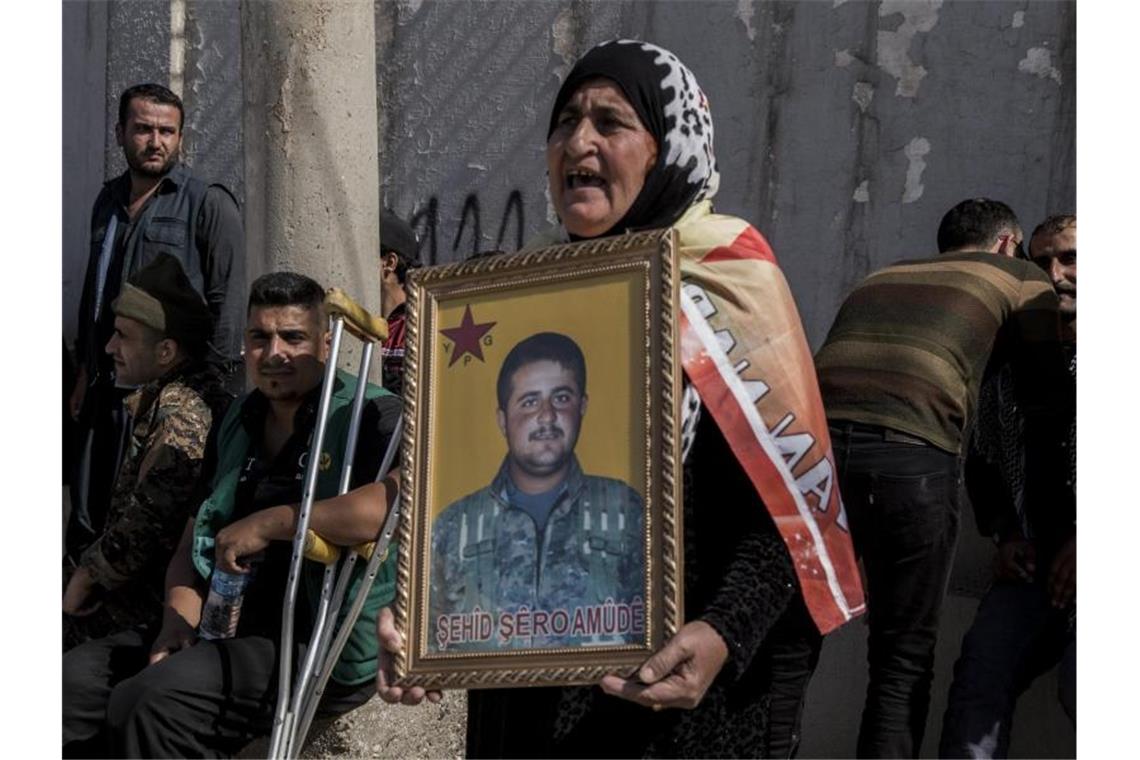 Protest gegen eine mögliche türkische Militäroffensive in Syrien: Eine Frau hält das Porträt eines kurdischen Kämpfers, der im Kampf gegen die Terrormiliz IS getötet wurde. Foto: Ahmad Baderkhan/AP/dpa