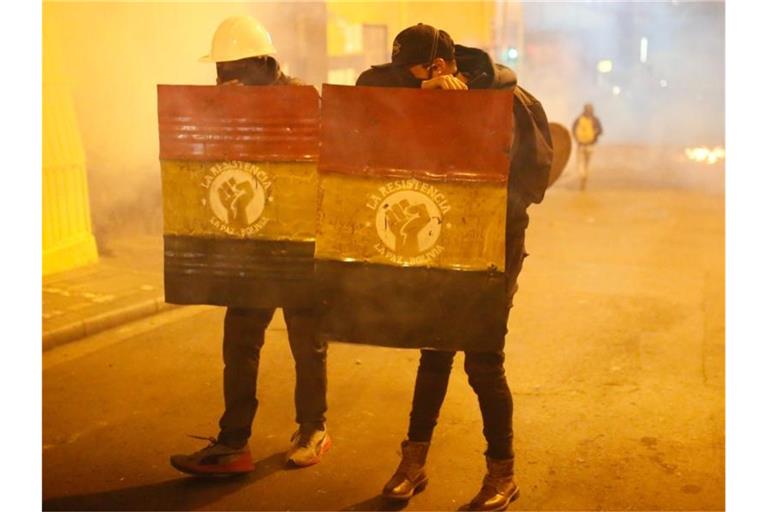 Protest gegen Präsident Morales: Demonstranten tragen Schilde mit der bolivianischen Flagge. Foto: Gaton Brito/dpa