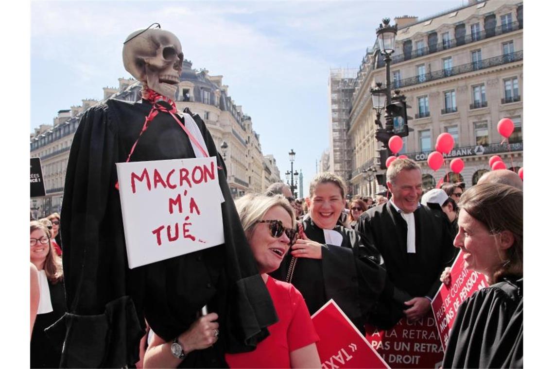 Protest in Paris: Ein Skelett in einer Richterrobe und einem Schild mit der Aufschrift „Macron hat mich getötet“. Foto: Michel Euler/AP/dpa