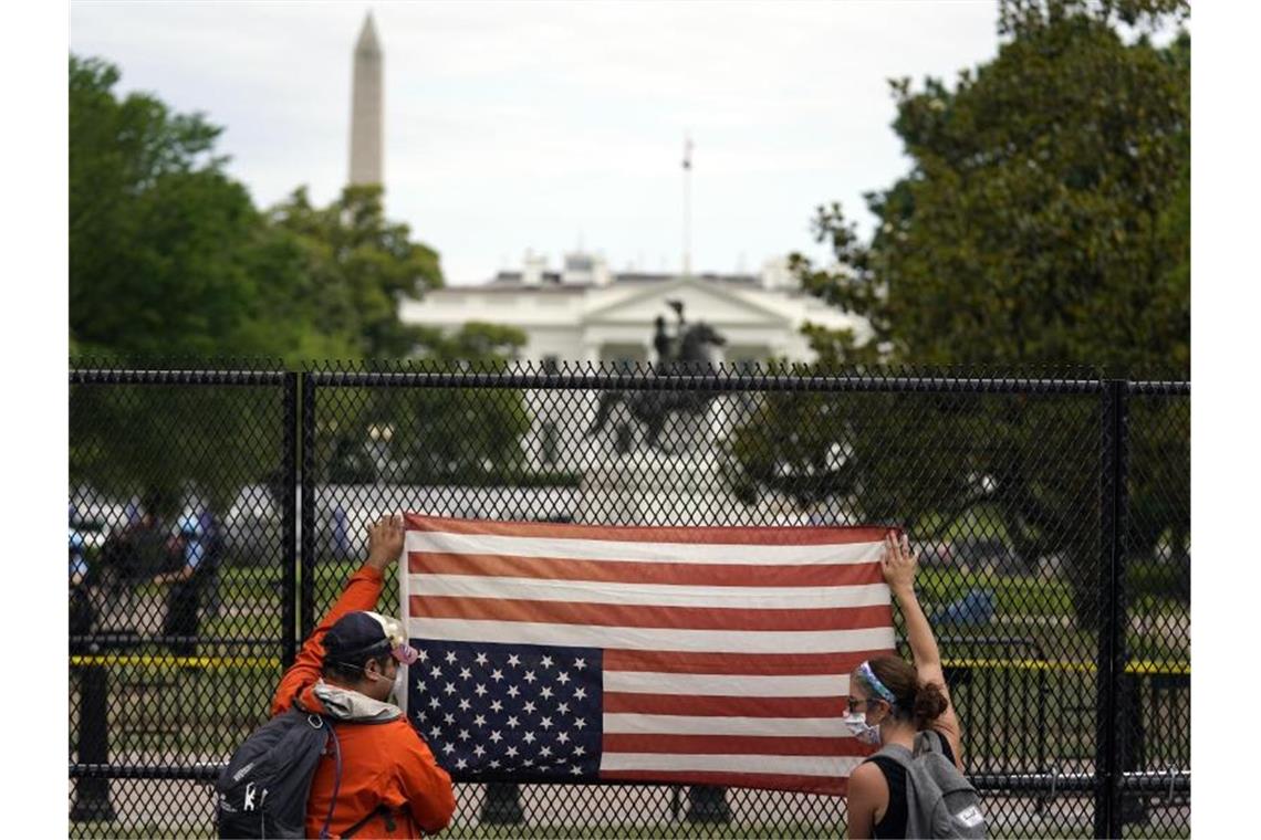 Protest mit einer umgedrehten US-Flagge vor dem Weißen Haus. Foto: Evan Vucci/AP/dpa