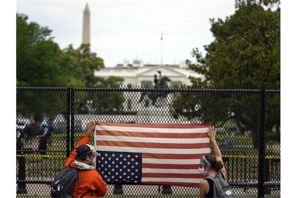 Trump droht Aufrührern mit Militär Protest mit einer umgedrehten US-Flagge vor dem Weißen Haus. Foto: Evan Vucci/AP/dpa