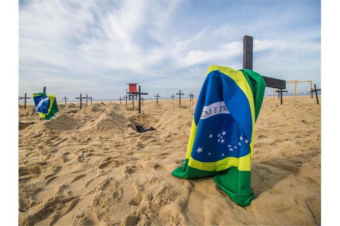 Protestaktion am berühmten Copacabana-Strand in Rio de Janeiro: Eine NGO hat Grabkreuze und brasilianische Flaggen aufgestellt. Foto: Ellan Lustosa/ZUMA Wire/dpa