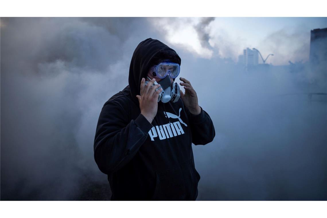 Bilder des Tages Proteste gegen Aktion von US-Bundeseinwanderungsbehörde - Eine Person reagiert auf Reizstoffe bei Protesten in der Nähe des Metropolitan Detention Center in Los Angeles.