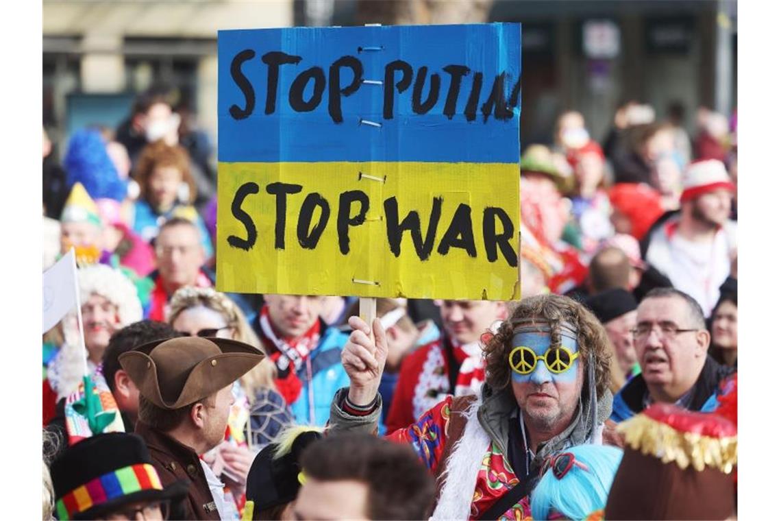 Straßenkarneval in Zeiten des Krieges Protestplakat gegen den Krieg beim Kölner Straßenkarneval. Foto: Oliver Berg/dpa