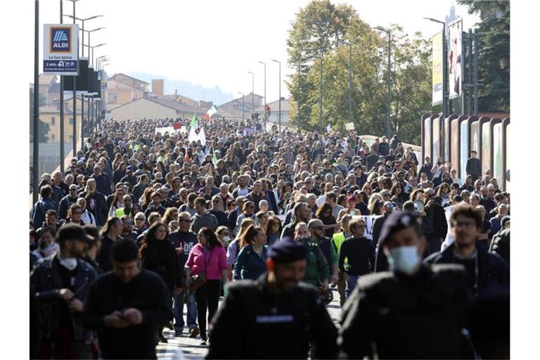 Protestteilnehmer sind in Bologna mit Fahnen auf der Straße, um gegen den sogenannten „Grünen Pass“ zu demonstrieren. Foto: Michele Nucci/LaPresse/AP/dpa
