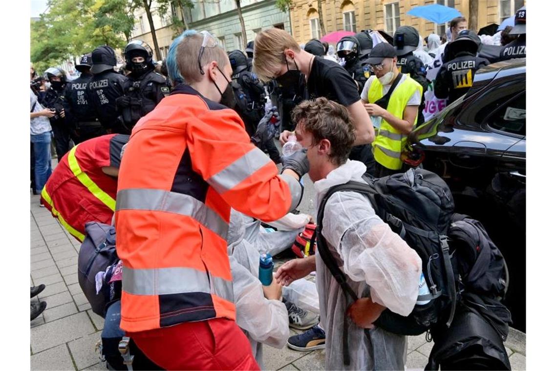 Protestteilnehmer werden von Sanitätern versorgt. Foto: Peter Kneffel/dpa