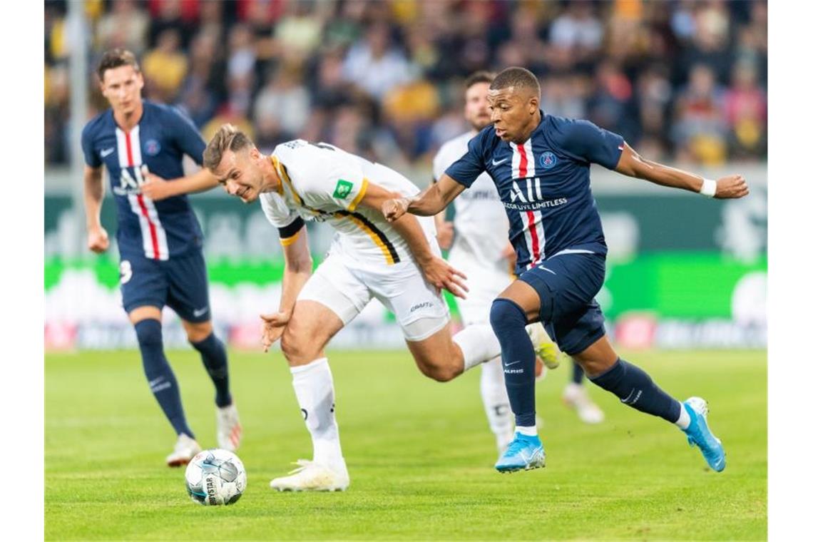 Mbappé-Show bei PSG-Torfestival bei Dynamo Dresden PSG-Star Pariser Kylian Mbappe (r) verfolgt Dynamos Florian Ballas, Julian Draxler (l) schaut zu. Foto: Robert Michael