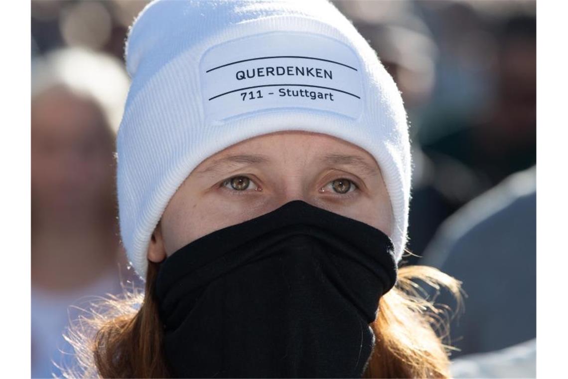Demos gegen Corona-Regeln am Wochenende im Südwesten "Querdenken 711 Stuttgart" steht auf der Mütze einer Teilnehmerin. Foto: Sebastian Kahnert/dpa-Zentralbild/dpa