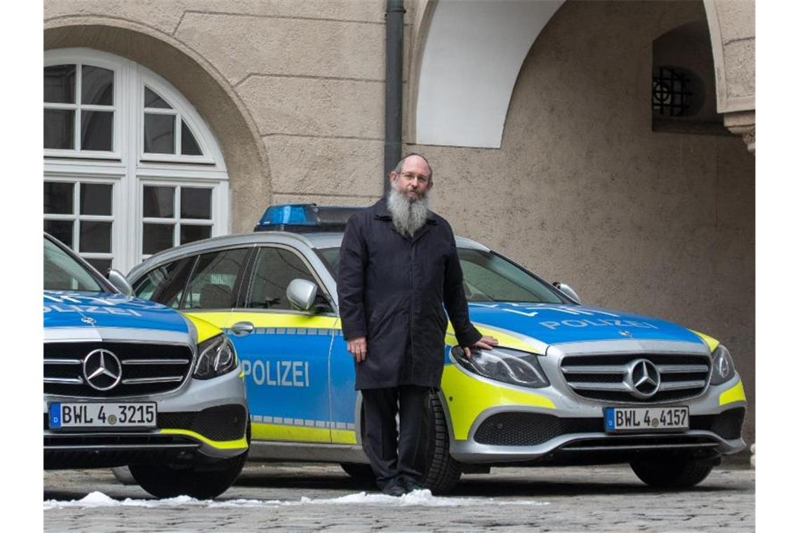Deutschlands erste Polizeirabbiner starten im Südwesten Rabbiner Shneur Trebnik steht im Polizeipräsidium zwischen zwei Streifenwagen. ). Foto: Stefan Puchner/dpa