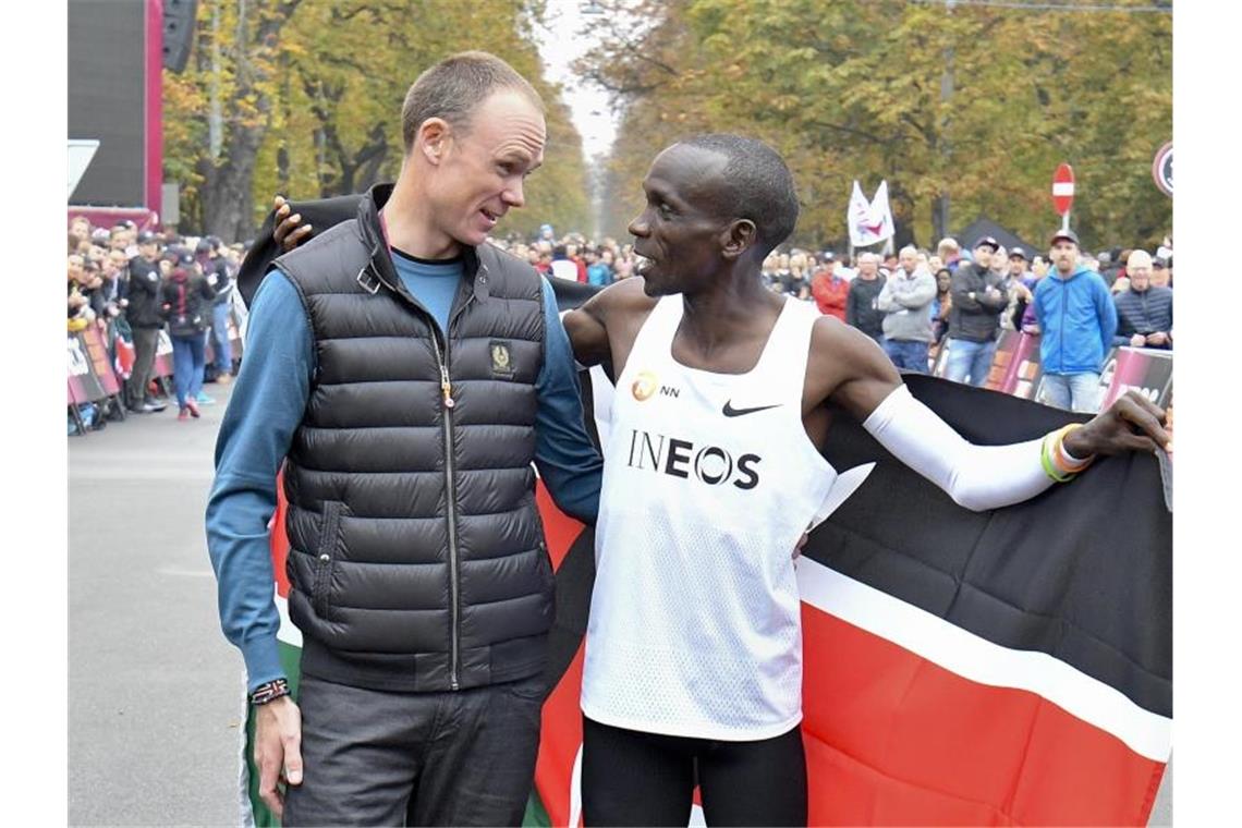 Radstar Chris Froome beglückwünscht Marathon-Weltrekordhalter Eliud Kipchoge in Wien direkt nach dem Zieleinlauf. Foto: Herbert Neubauer/APA/dpa