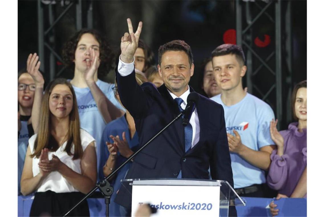 Knapper Sieg sichert Duda zweite Amtszeit Rafal Trzaskowski (M), Bürgermeister von Warschau und Präsidentschaftskandidat von Polens größtem Oppositionsbündnis, zeigt ein Victory-Zeichen. Foto: Petr David Josek/AP/dpa