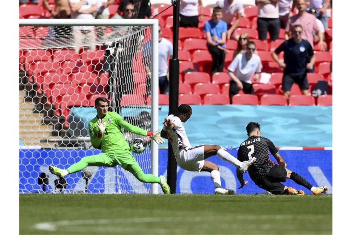 Raheem Sterling (M) schießt den Ball zum 1:0 ins Tor. Foto: Laurence Griffiths/Pool Getty/AP/dpa