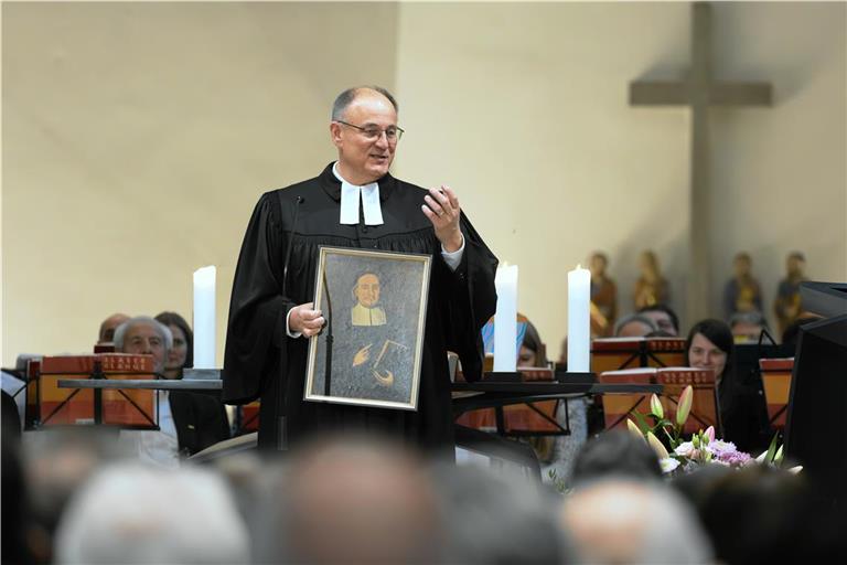 Rainer Köpf präsentiert bei dem Gottesdienst anlässlich seiner Investitur ein Gemälde von Paul Gerhardt. Über diesen Dichter vieler Kirchenlieder hat der neue Dekan bereits ein Buch geschrieben. Foto: Alexander Becher