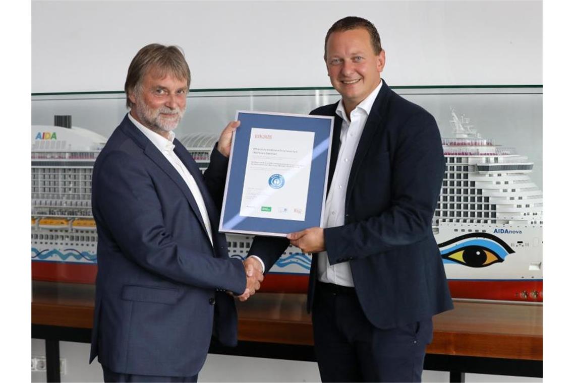 Bundesregierung verleiht Kreuzfahrtschiff Umweltsiegel Ralf-Rainer Braun (l), Vorsitzender der Jury Umweltzeichen, überreicht Felix Eichhorn, Präsident von Aida Cruises, die Urkunde „Blauer Engel“. Foto: Bernd Wüstneck
