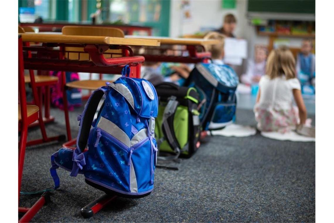 Ranzen hängen und stehen beim Begrüssungsunterricht der neuen Erstklässler im Klassenzimmer. (Archivbild). Foto: Philipp Schulze/dpa