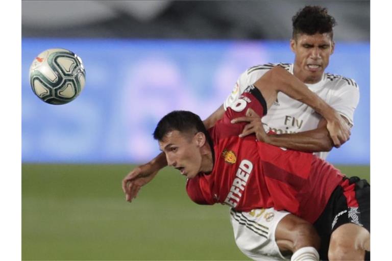 Raphael Varane (r) von Real Madrid kämpft gegen Ante Budimir (l) vom RCD Mallorca um den Ball. Foto: Bernat Armangue/AP/dpa