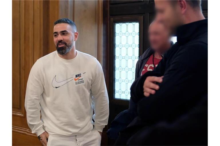 Rapper Bushido (l) kommt in Begleitung von Personenschützern der Polizei in einen Saal des Bundesverwaltungsgerichtes. Foto: Sebastian Willnow/dpa-Zentralbild/dpa