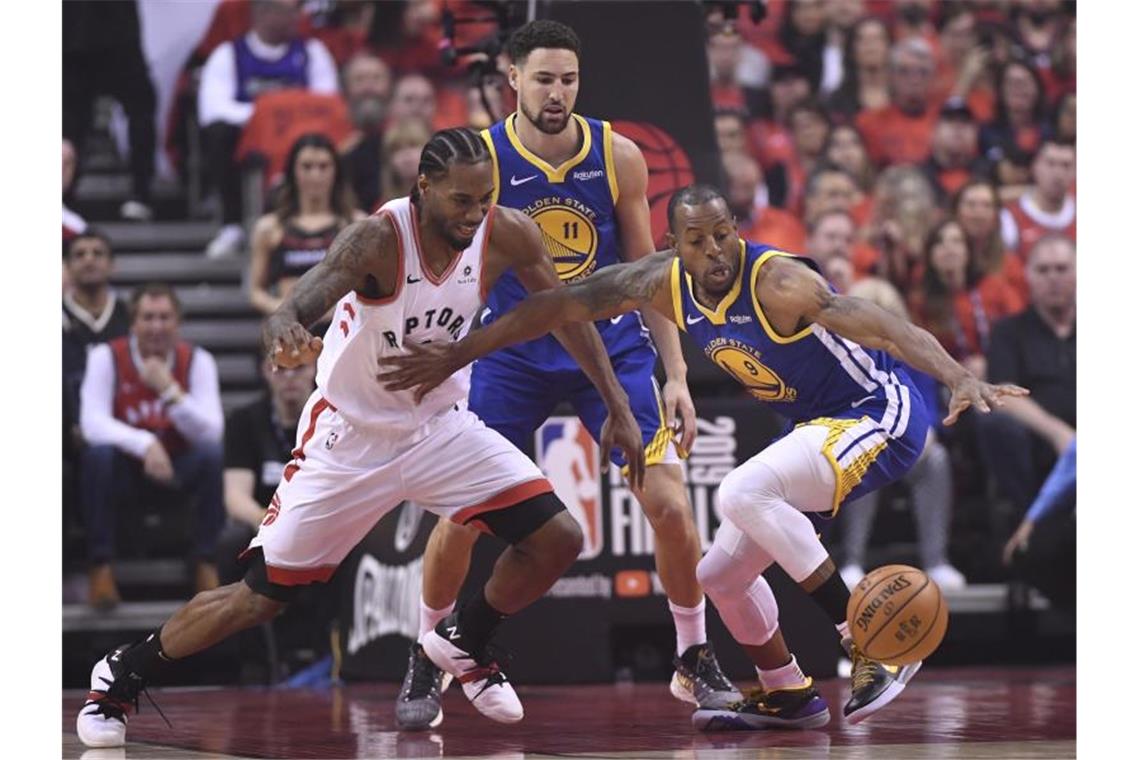 Raptors-Star Kawhi Leonard (l) im Kampf um den Ball mit Andre Iguodala (r) von den Warriors. Foto: Frank Gunn/The Canadian Press