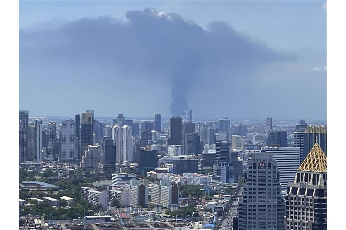 Großbrand nach Explosion in Chemiefabrik bei Bangkok Rauch hinter der Skyline von Bangkok auf. In Thailand ist es in einer Chemiefabrik zu einer schweren Explosion gekommen. Foto: Tina Liu/AP/dpa