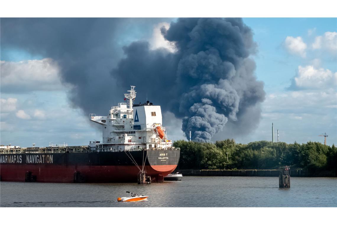 Rauch ist hinter einem Schiff zu sehen; in der Nähe des Einsatzortes fließt die Norderelbe.