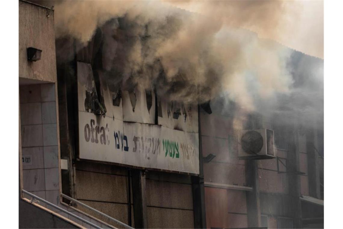 Israel tötet Dschihad-Militärchef - Beschuss aus Gaza Rauch quillt aus einer brennenden Fabrik in Sderot, die von einer Rakete aus Gazas getroffen wurde. Foto: Ilia Yefimovich/dpa