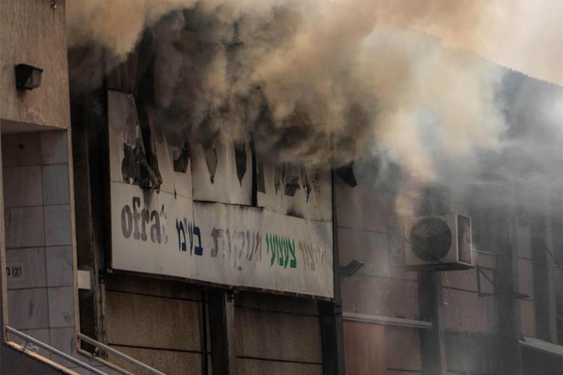 Rauch quillt aus einer brennenden Fabrik in Sderot, die von einer Rakete aus dem Gazastreifen getroffen wurde. Foto: Ilia Yefimovich/dpa