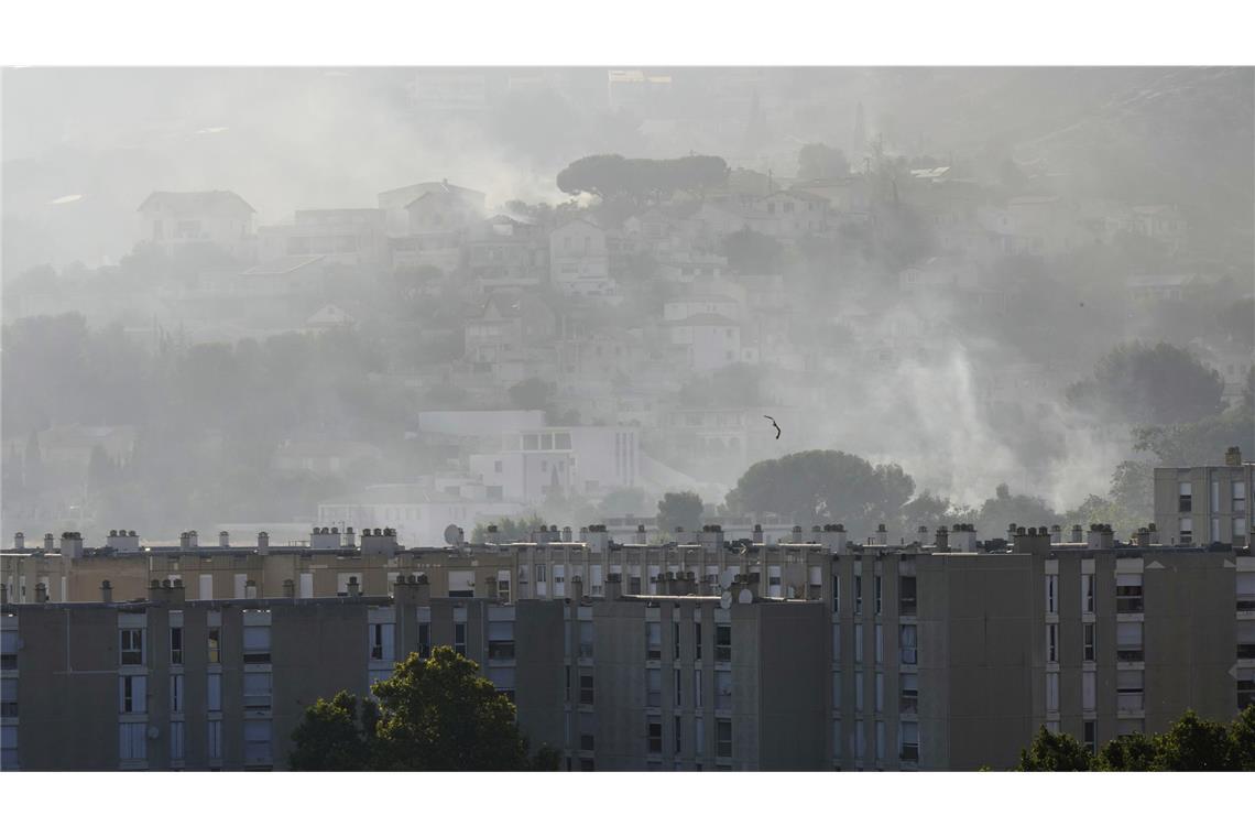 Rauch steigt hinter Gebäuden im Stadtteil La Castellane während eines Waldbrandes.