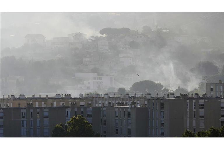 Rauch steigt hinter Gebäuden im Stadtteil La Castellane während eines Waldbrandes.
