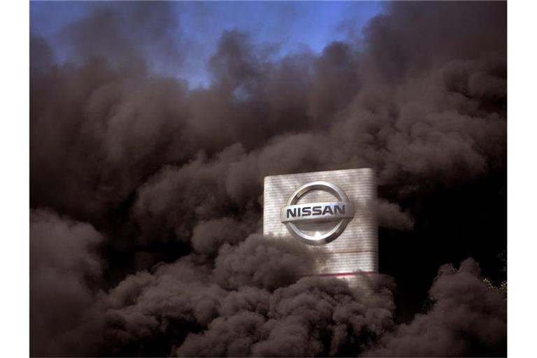 Rauch steigt über dem Nissan-Werk in Barcelona auf, als Arbeiter bei einer Protestaktion Reifen verbrennen. Foto: Emilio Morenatti/AP/dpa