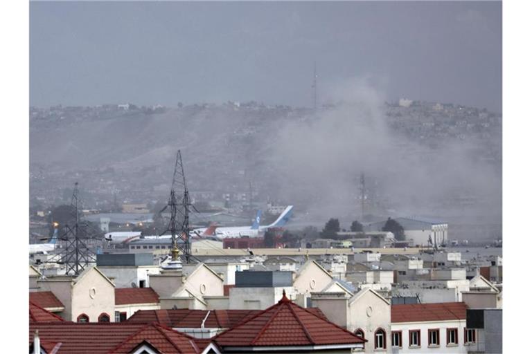 Rauch steigt von einer der Explosionen außerhalb des Flughafens auf. Foto: AP/dpa