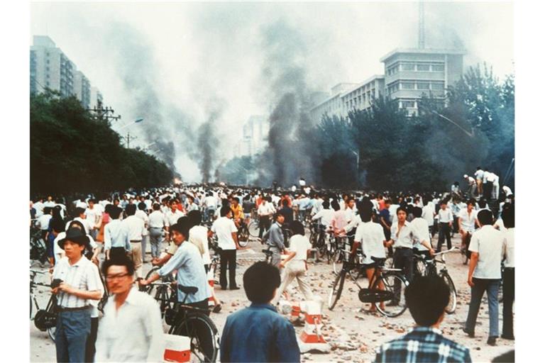 Rauchsäulen, Verwüstung und ratlose Menschen am 4. Juni 1989 auf der Changan Avenue in Peking. Foto: Kyodo News