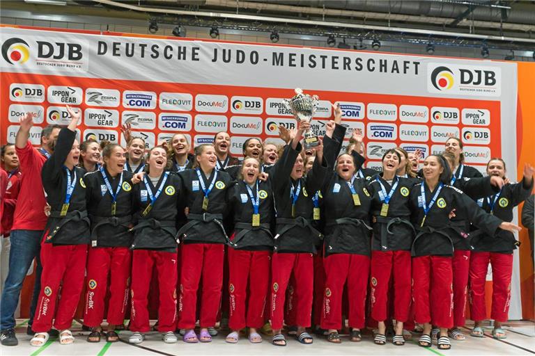 Die Judofrauen der TSG Backnang sind deutscher Rekordmeister Recken schon zum sechsten Mal binnen neun Jahren die Trophäe für den Deutschen Meister in die Höhe: Die Judofrauen der TSG und Trainer Jens Holderle (hinten links). Foto: Cedrik Strupp