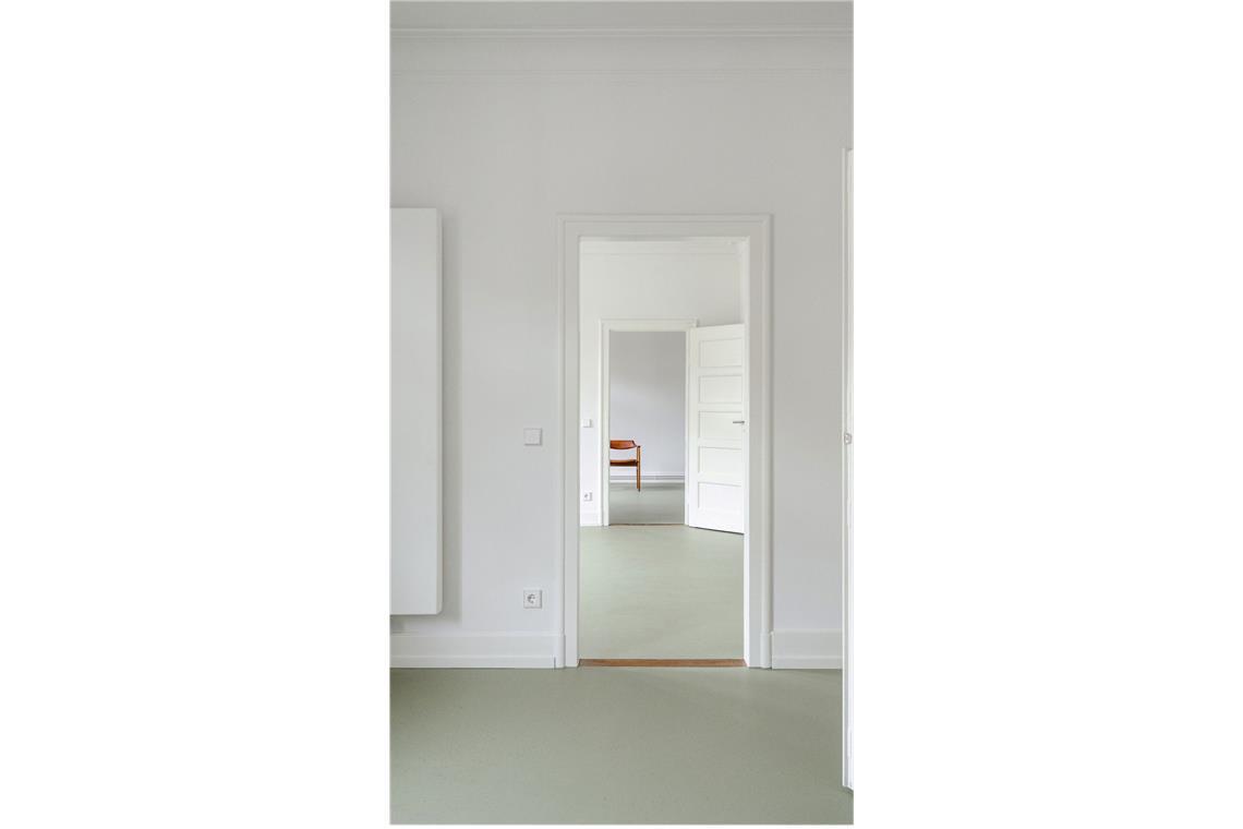 Reduzierte Farbwahl in der 95 Quadratmeter großen Stuttgarter Wohnung.  Der salbeigrüne Linoleum-Boden ist durchgängig verlegt worden.